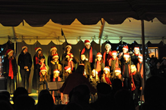 Carolers perform on stage at the 2nd Annual Charlie Brown Christmas Tree Grove on Windsor Town Green.